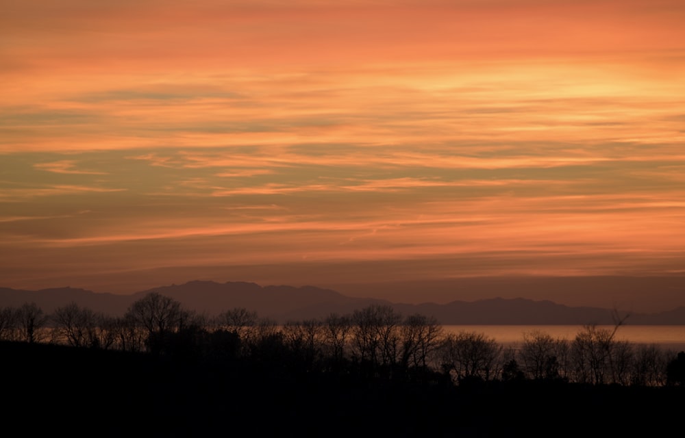 a sunset view of the mountains and water