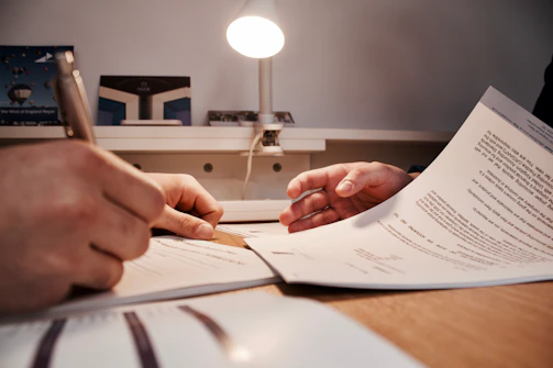 Close-up of hands signing a transparent contract with a pen.