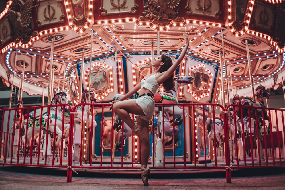 woman sitting on metal rails by turned on merry-go-roudn