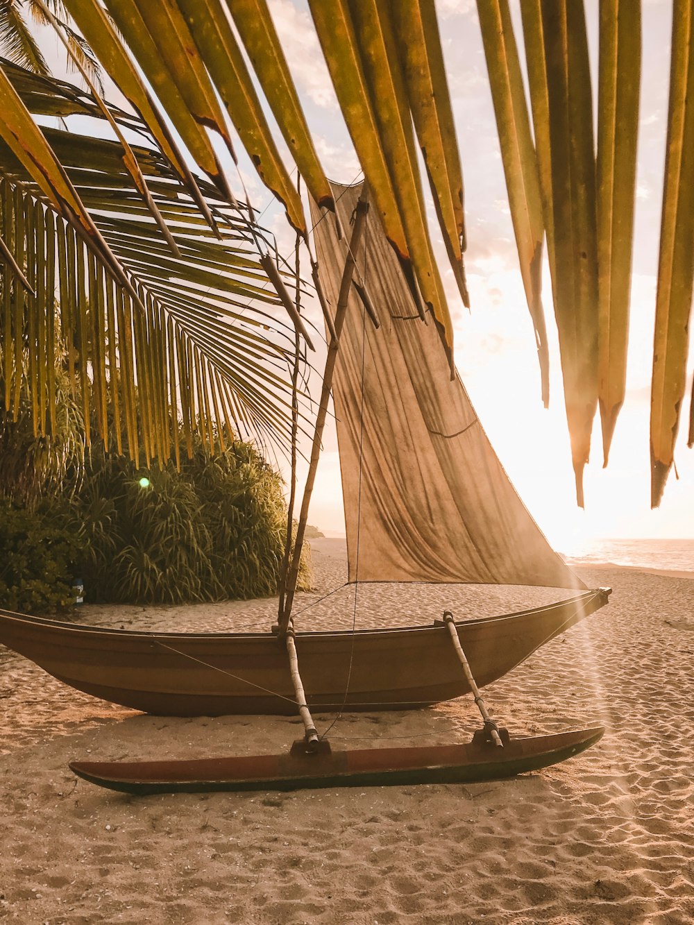 brown wooden canoe beside beach