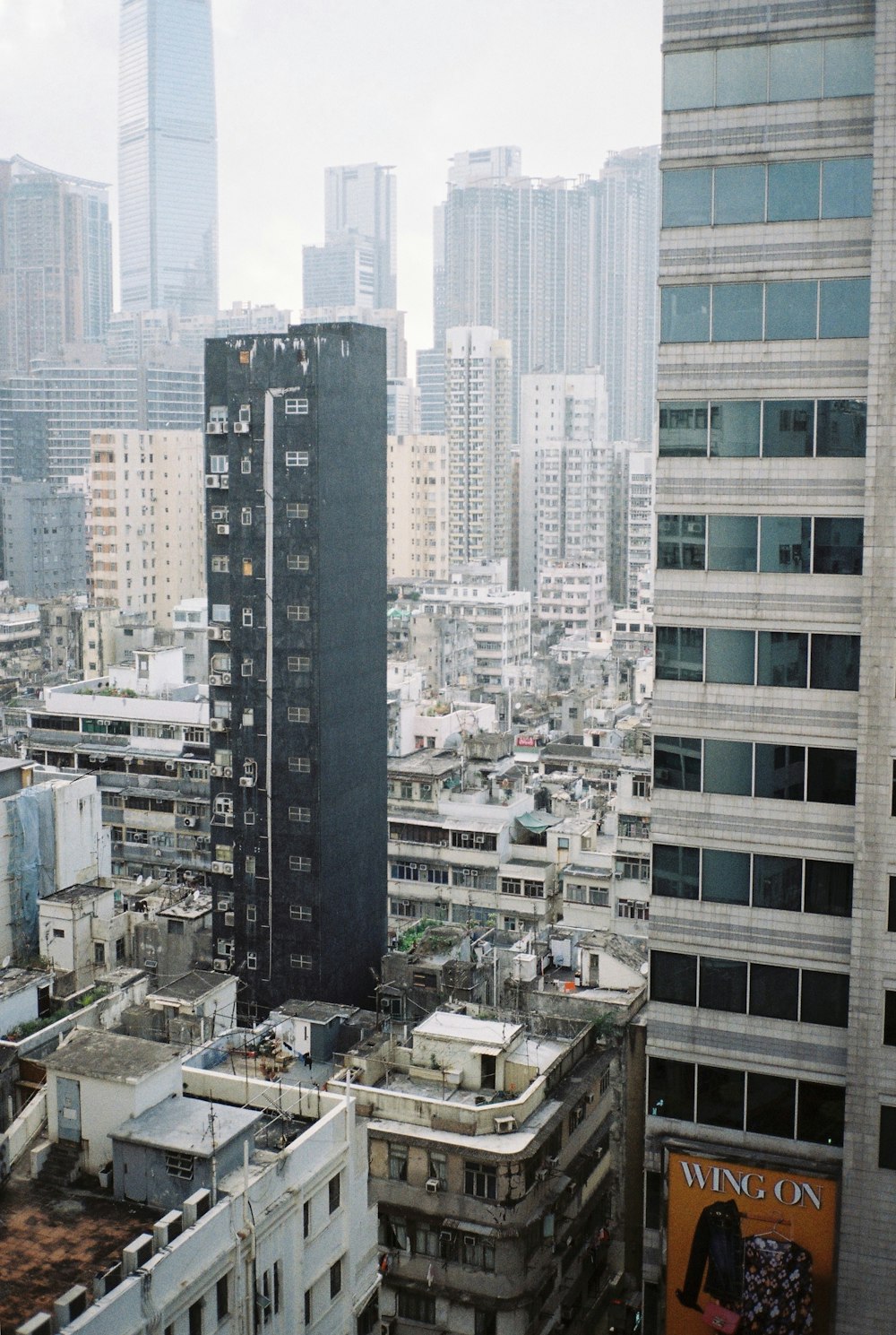 black concrete building surrounded by white buildings