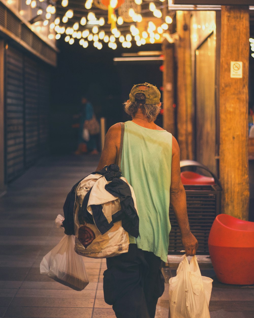 person carrying clothes walking on alley