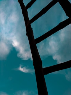 A sturdy ladder set up against a bright blue sky, ready for use