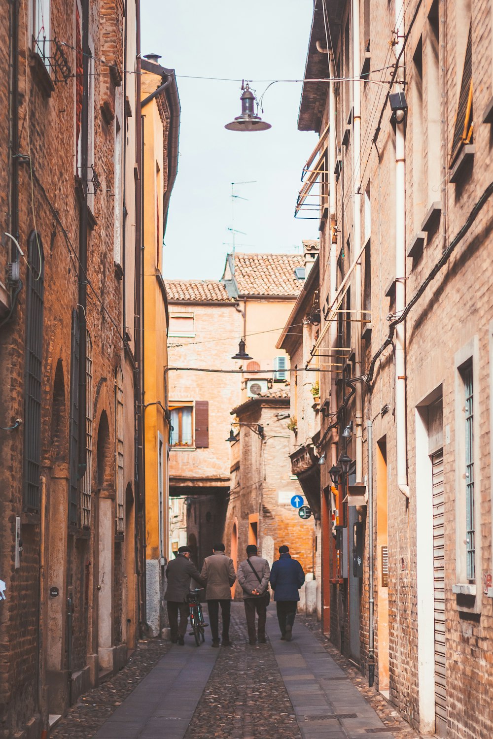 four person standing between buildings