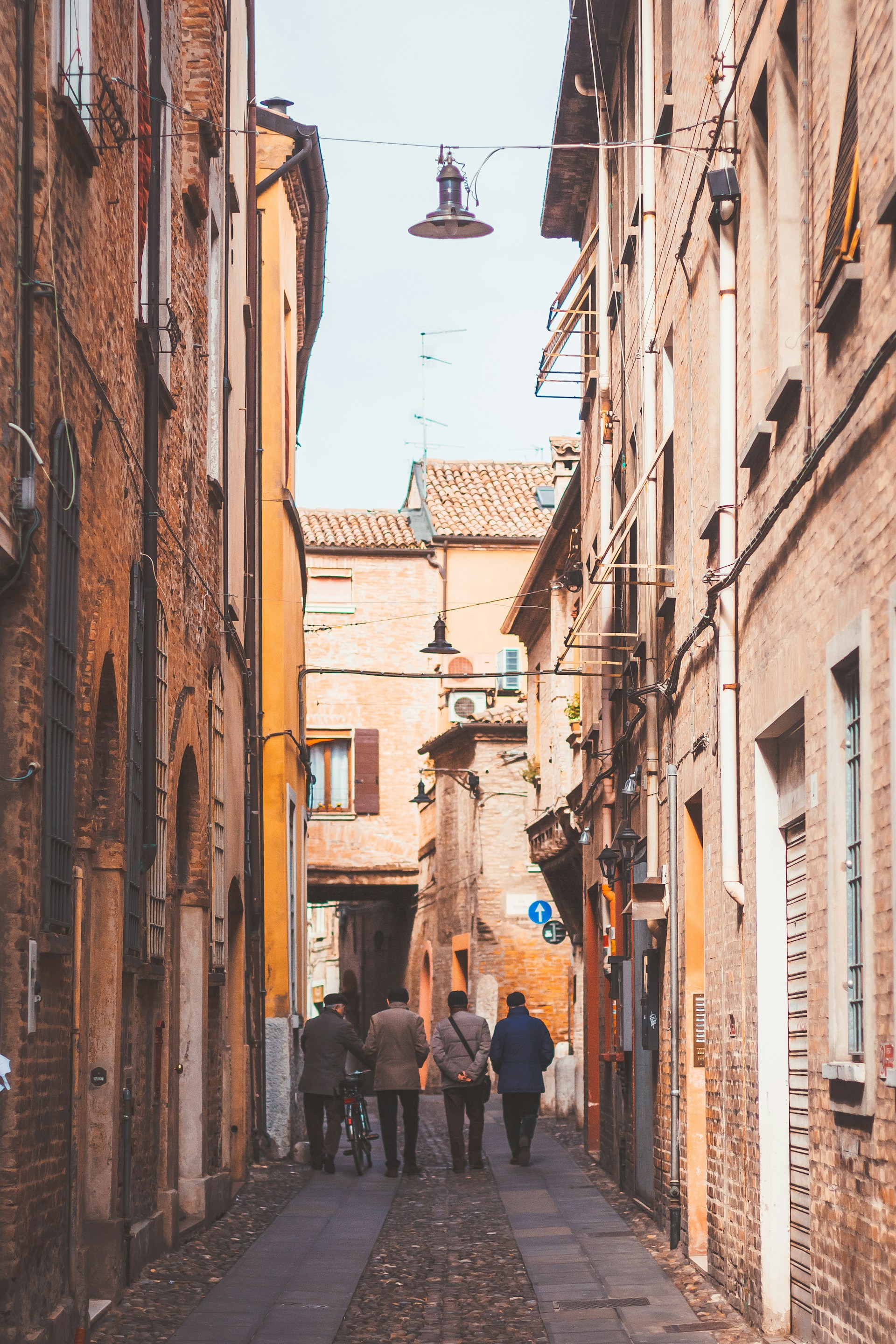 four person standing between buildings