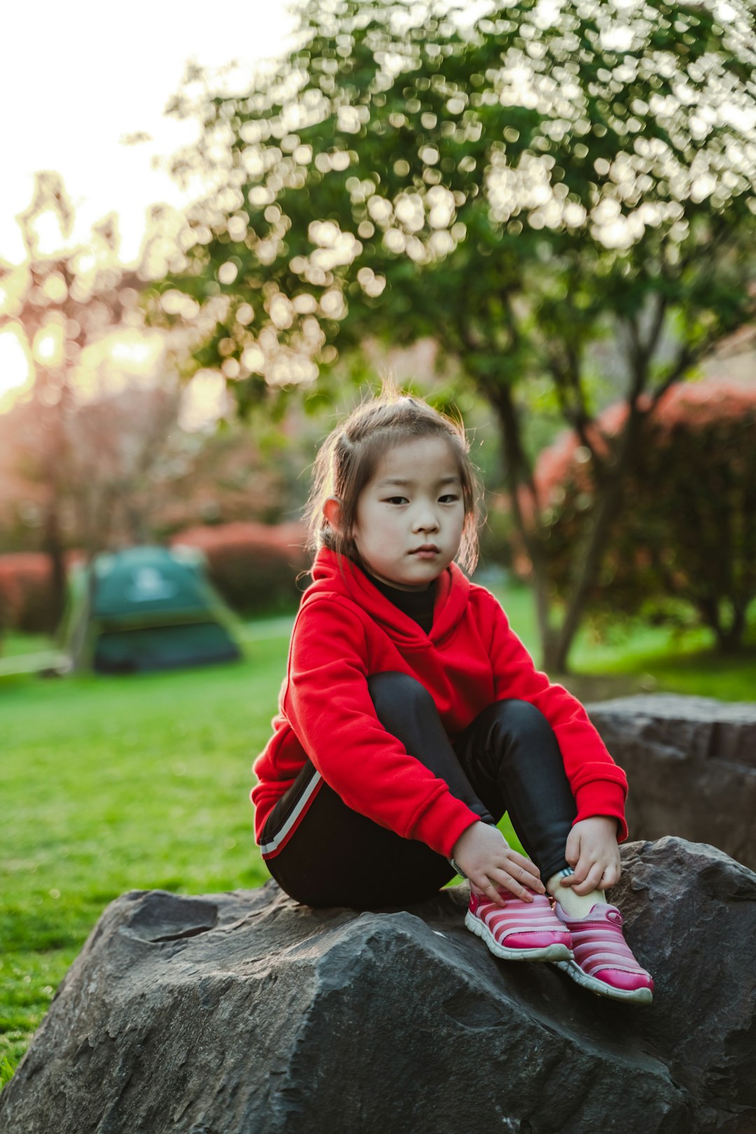 girl sitting on rock during daytime