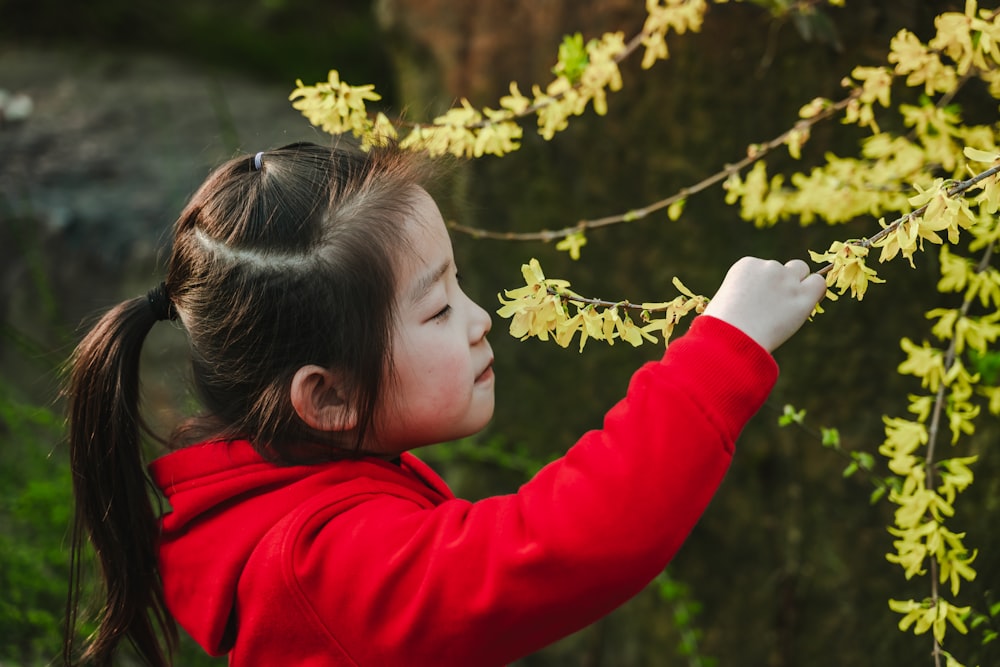 girl standing and smelling green plant