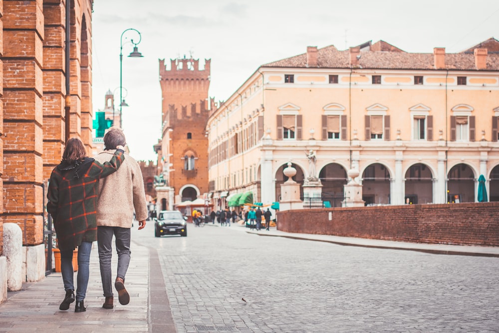 man and woman walking on sidewalk