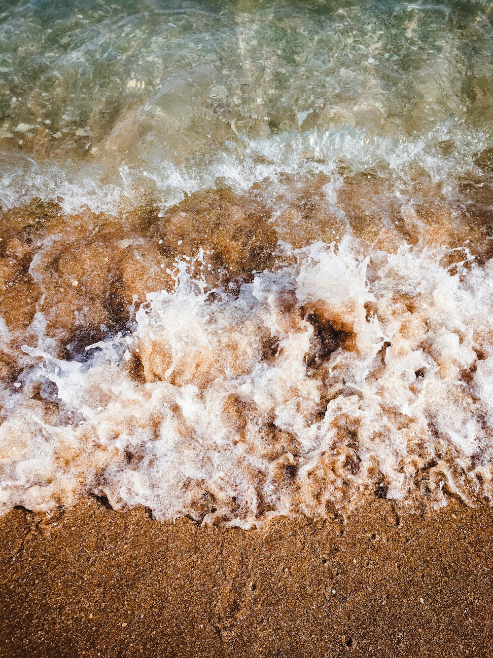 brown sand on body of water