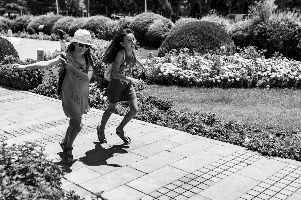 two girls walking on road