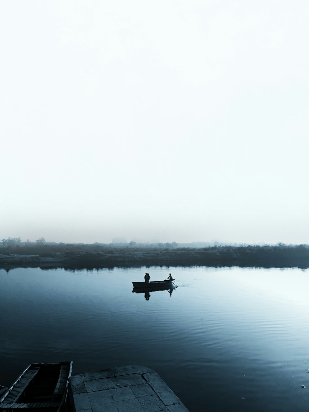 person riding a boat on calm body of water