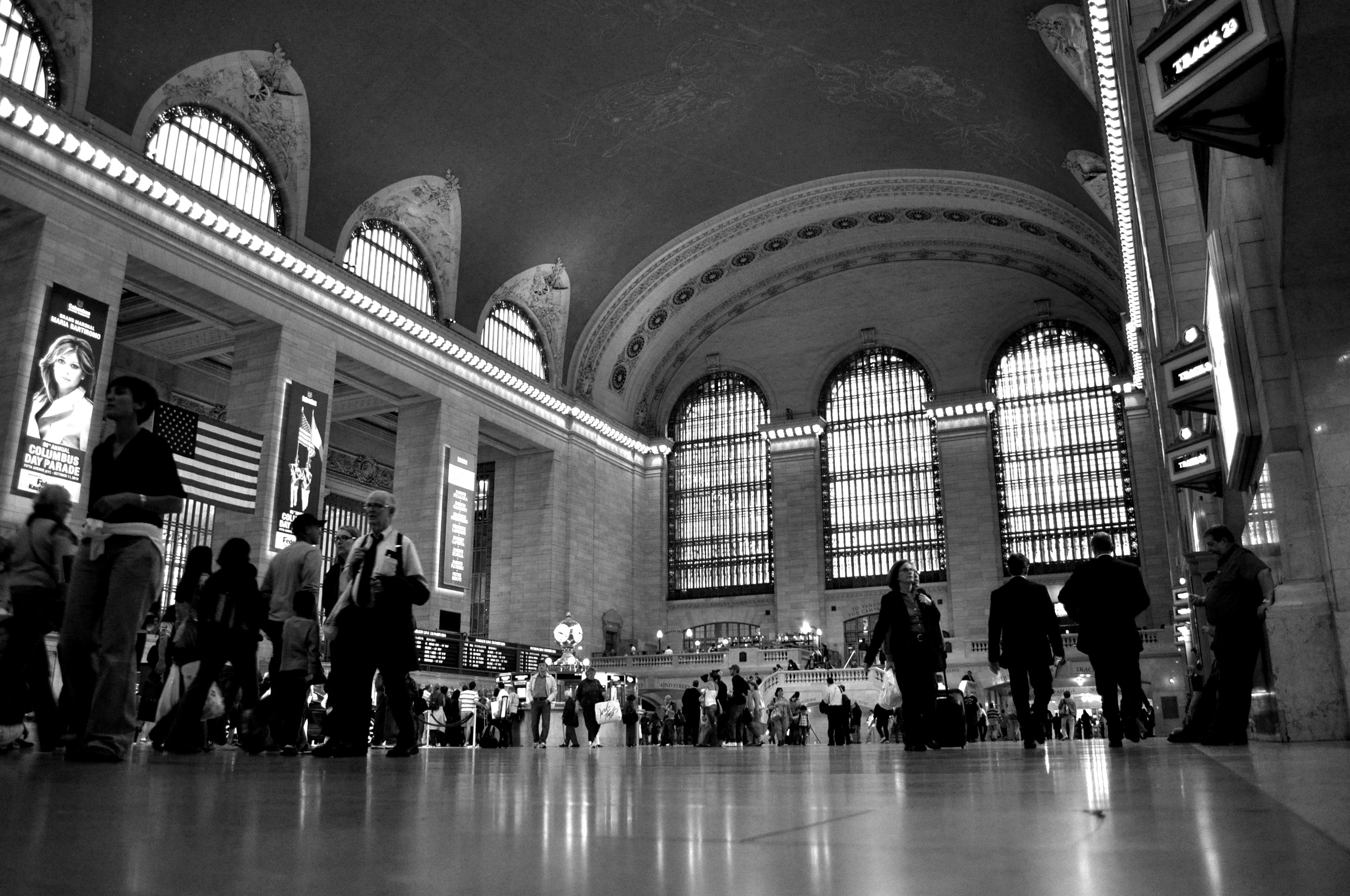 grayscale photography of people walking in building