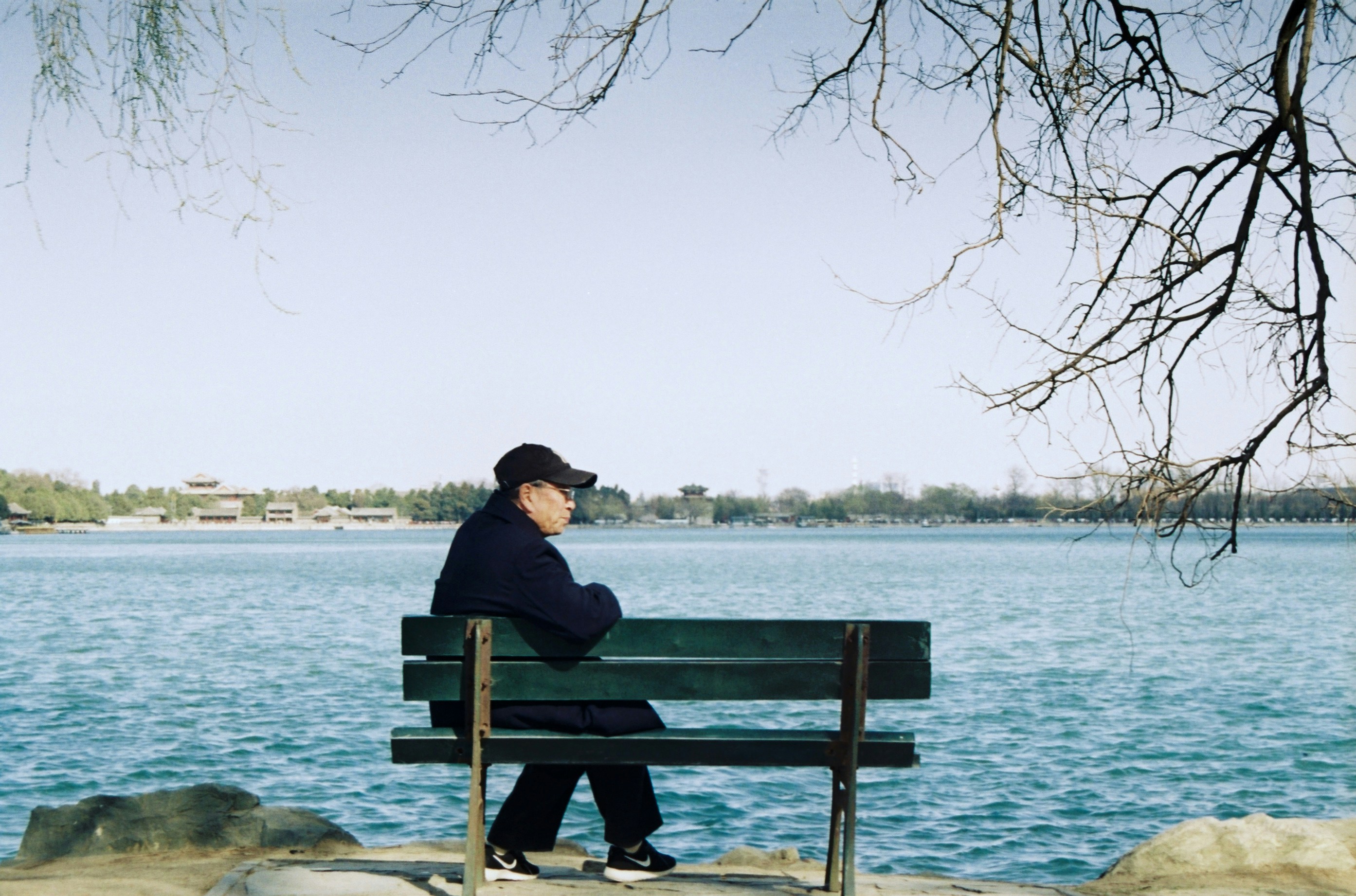 man sitting on blue wooden bench