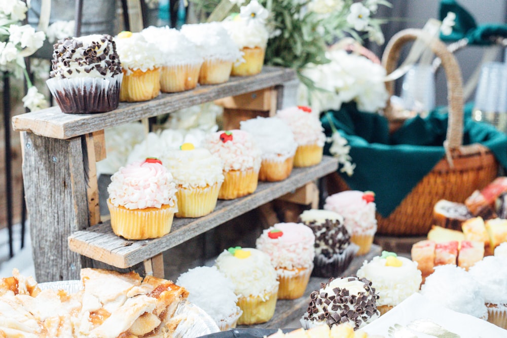 cupcakes on wooden stand beside basket