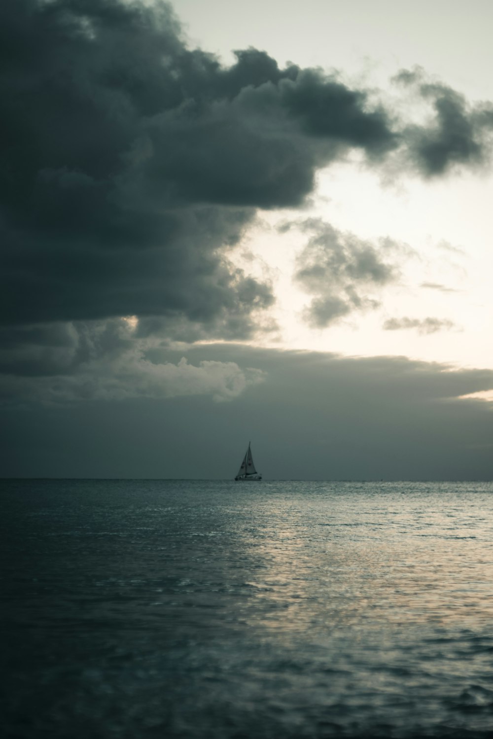 sailing boat under nimbus clouds