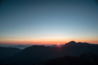 A scenic view of a mountain range at sunrise.