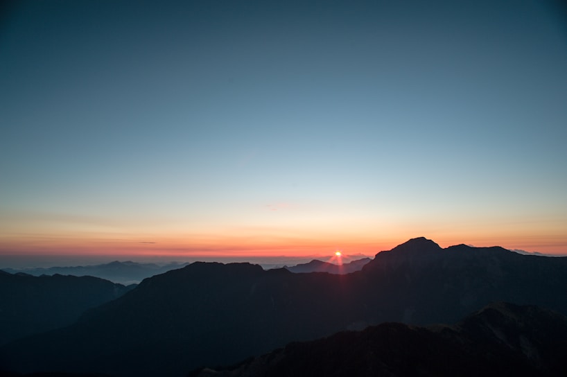 A scenic view of a mountain range at sunrise.