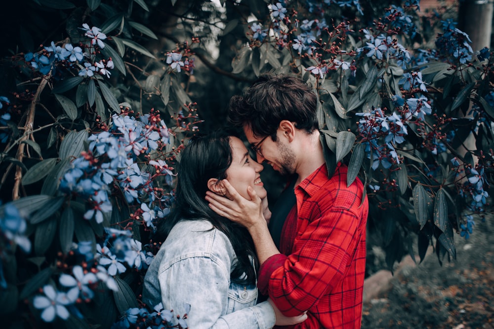 man and woman standing near plant