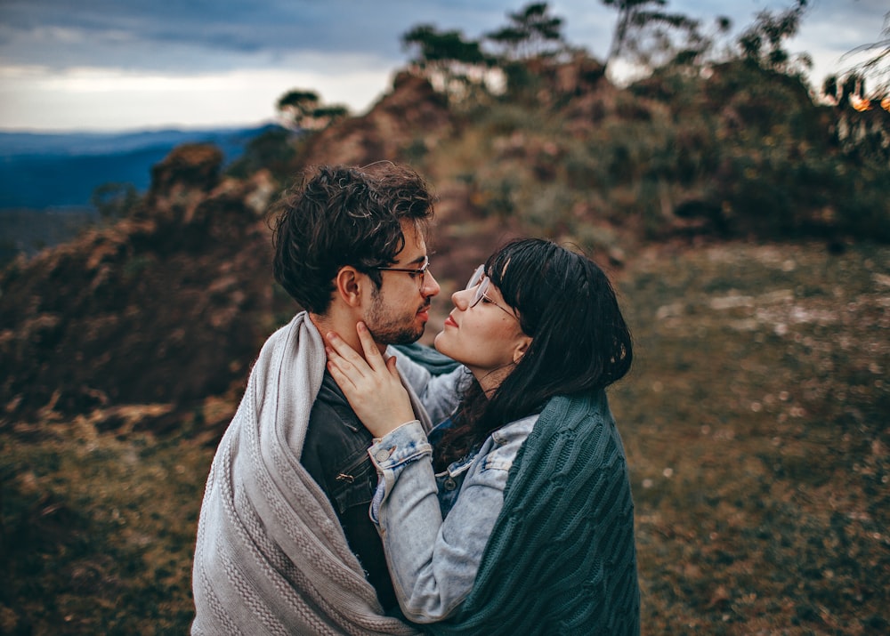 hugging man and woman wrapped in blanket