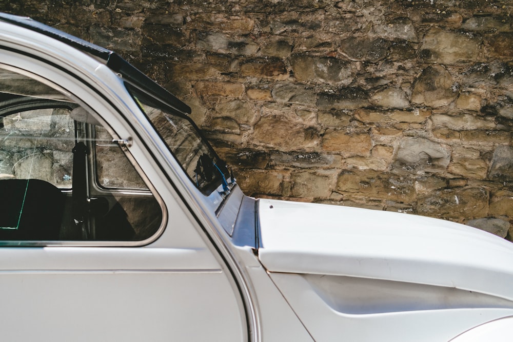 white vehicle parked near brown wall