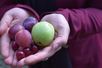 A close-up of hands sorting through colorful fruits.