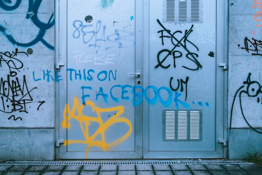 gray metal door with graffiti