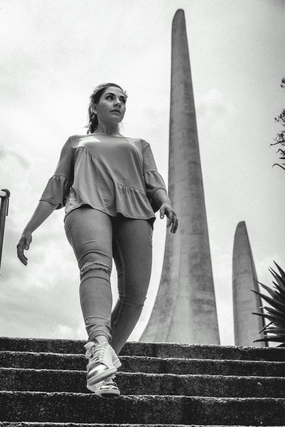 grayscale photo of woman walking down stairs