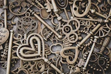 A collection of engraved keychains laid out on a rustic table, each with unique names and dates.