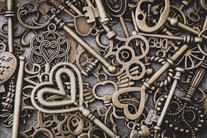 A collection of keyrings in pastel blues and warm neutrals, each featuring subtle allynest symbols on a textured fabric surface.