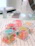 Close-up of colorful jelly gummies spilling out of a sleek, modern container on a wooden table.