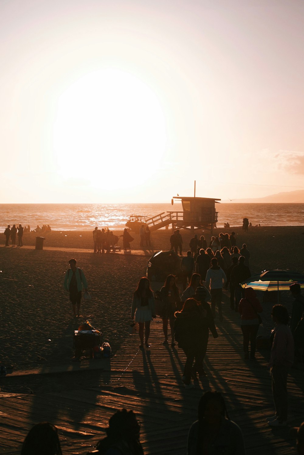 people walking on shore during golden hour