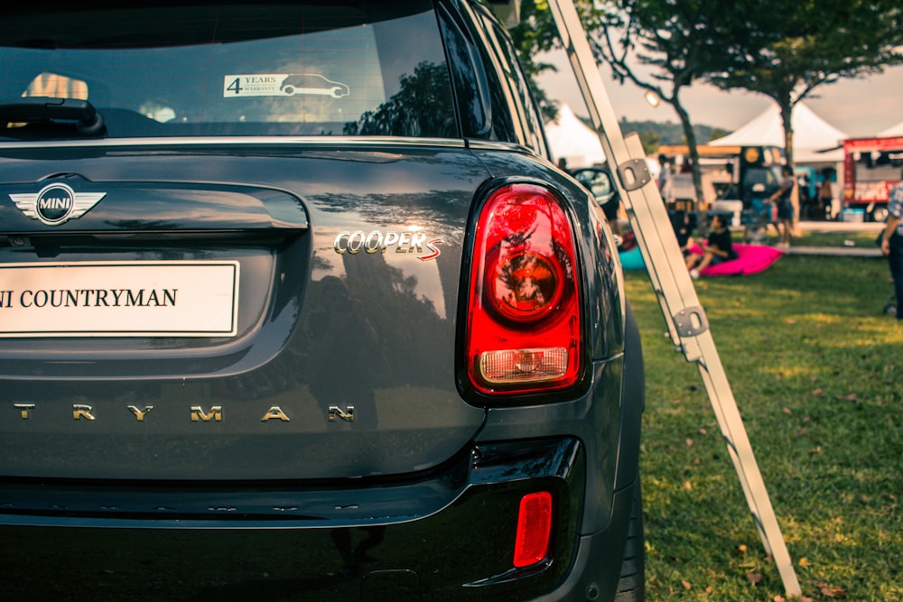 a car parked in the grass with a sign on the back of it