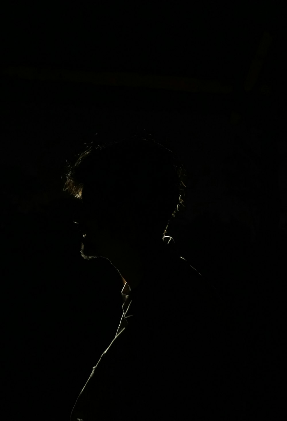 silhouette of man in dark room