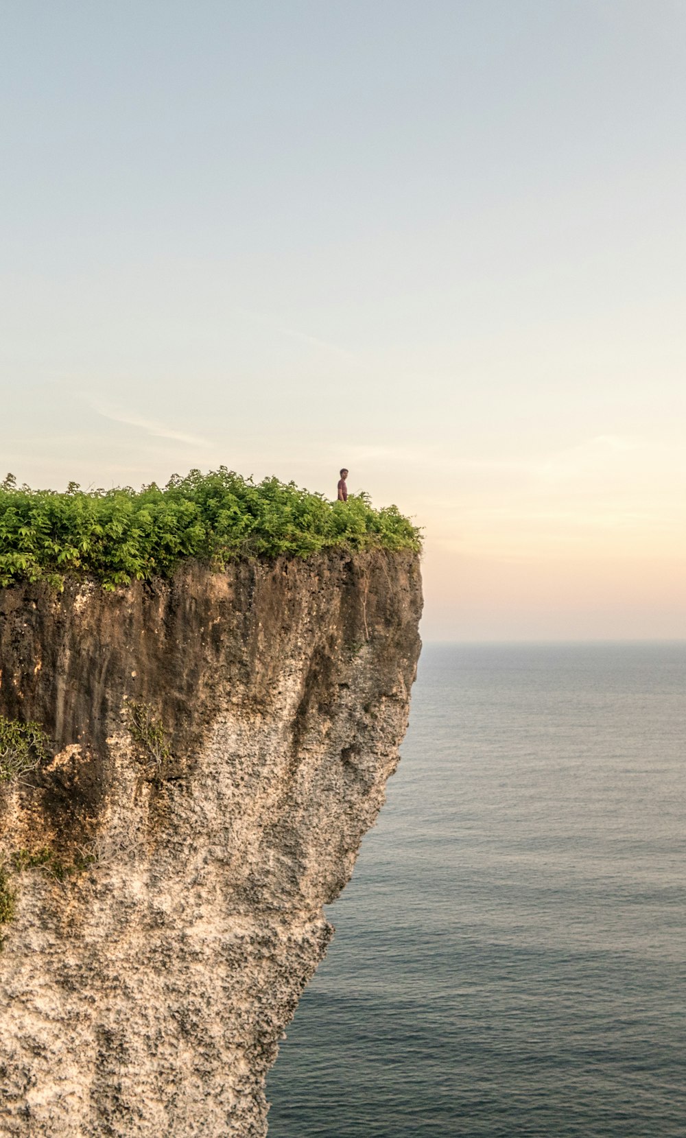 person standing on cliff during daytime