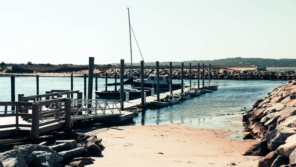 gray wooden dock beside motor boats during daytime