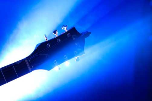 Artistic shot showcasing detailed digital blueprints of a guitar design on a laptop screen.