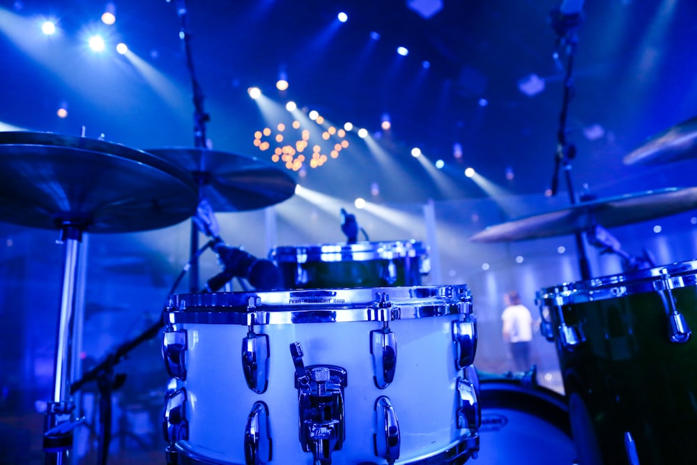 selective focus photography of white acoustic drum kit