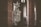 An ornate religious artifact, featuring detailed carvings and symbols, is prominently displayed in a dimly lit interior of a church. The background includes large stone columns and softly filtered natural light coming through an arched window.