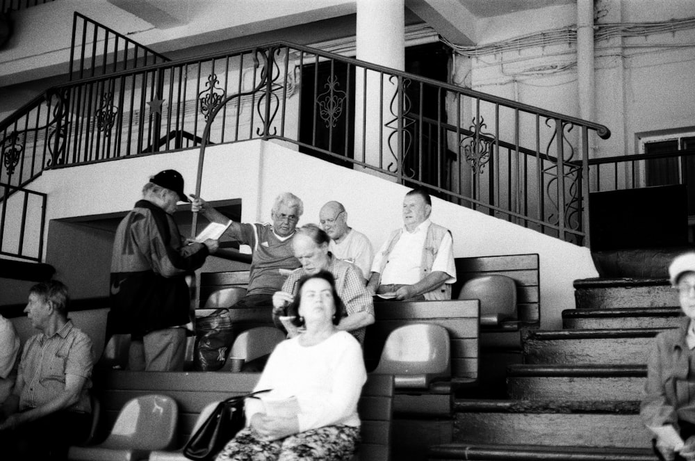 grayscale photography of people sitting on bench