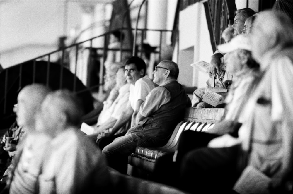 grayscale photo of people sitting on bench