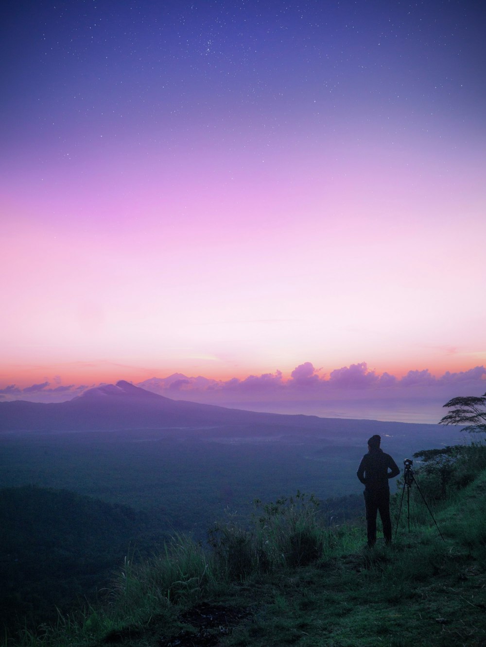 person standing on the cliff of the mountain