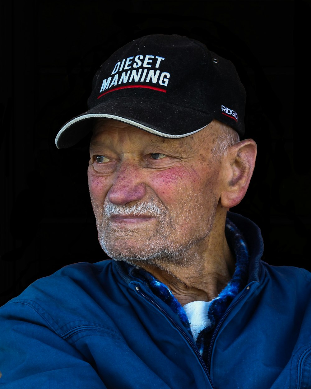 man wearing black cap looking to his right