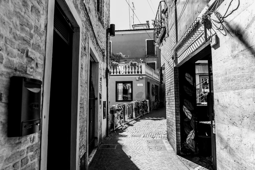 Photographie en niveaux de gris d’une ruelle entre les bâtiments