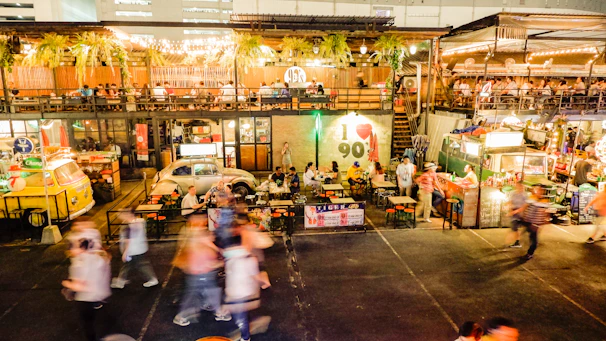 A lively food festival with people enjoying diverse gourmet dishes and vibrant ambiance.