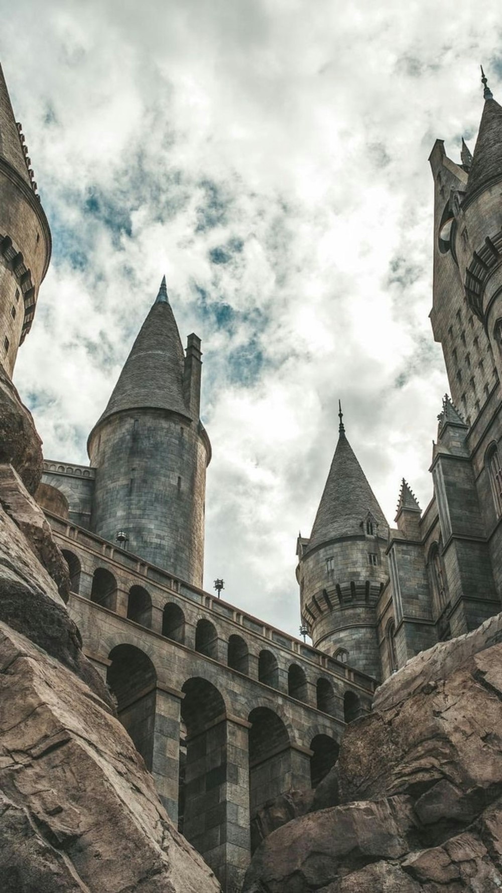 Weiße Wolken schweben über dem grauen Schloss