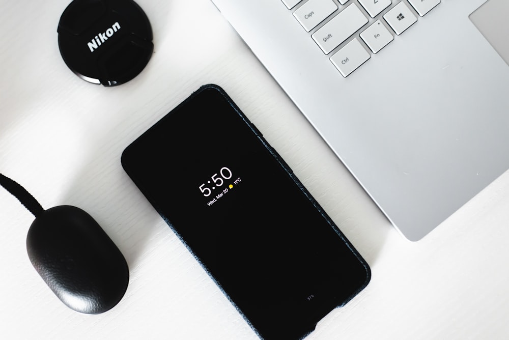 smartphone Android noir à côté d’un ordinateur portable gris