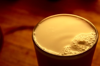 A close-up of fresh milk being poured into a glass, highlighting its creamy texture.