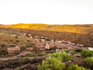A traditional Berber village nestled in a lush valley surrounded by towering mountains.