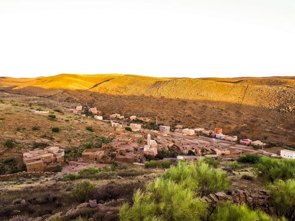A traditional Berber village nestled in a lush valley surrounded by towering mountains.