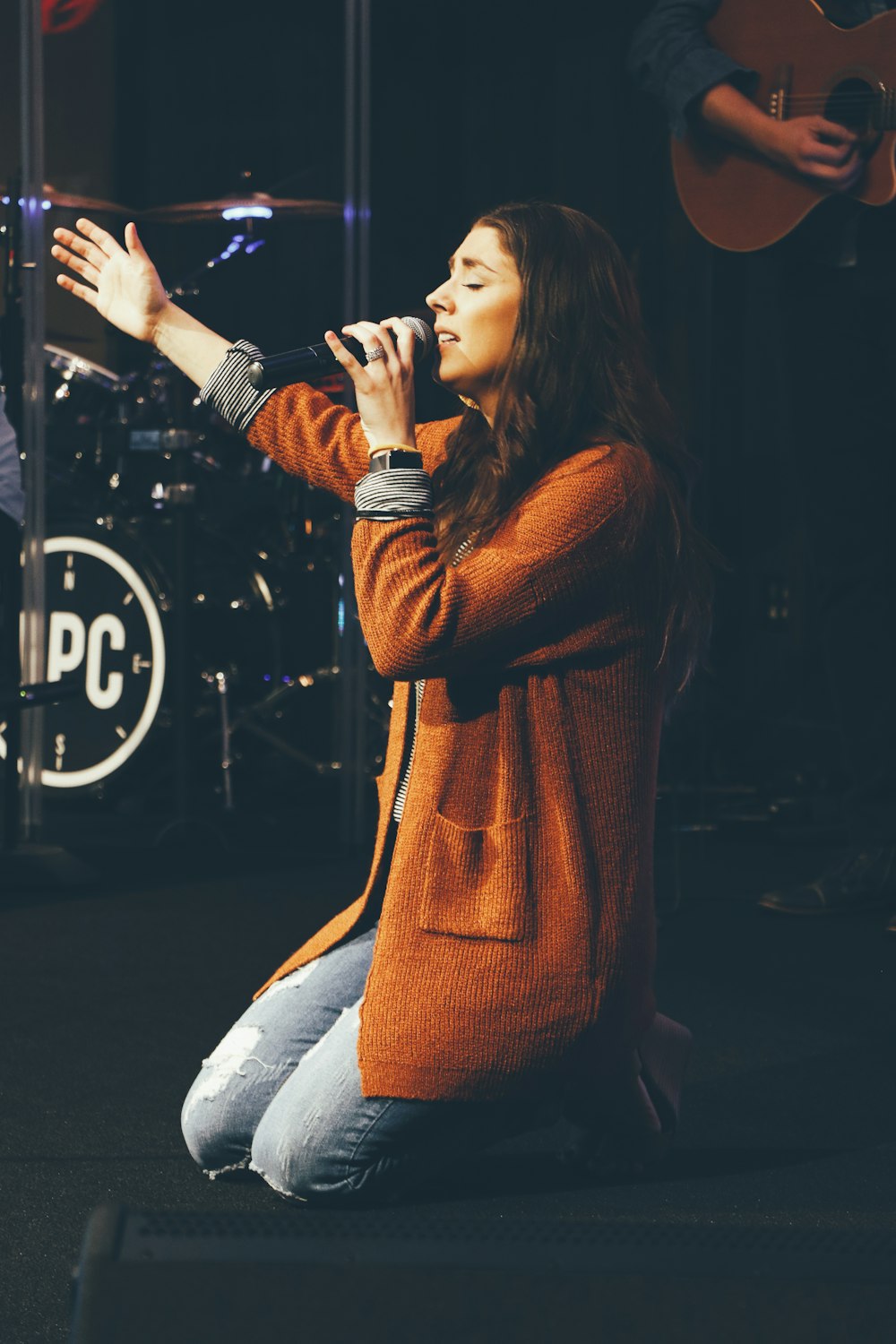woman kneeling while holding microphone